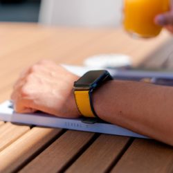 Submarine-Apple-watch-yellow-rubber-band-on-top-of-a-designer-magazine
