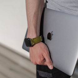 AW-bullet-proof-green-leather-band-handling-a-silver-macbook