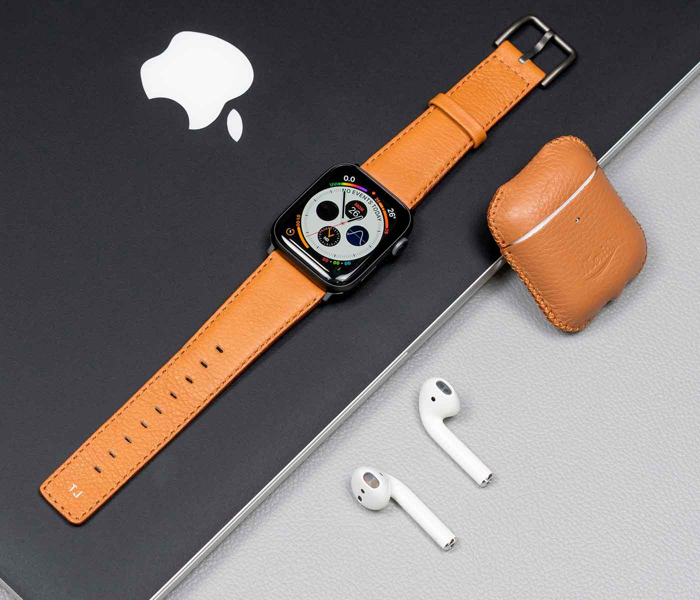 Apple-combo-light-brown-accessories-with-monogram-on-top-of-a-grey-macbook-bs