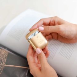 Topaz-Airpods-gold-leather-case-in-her-hands-bs