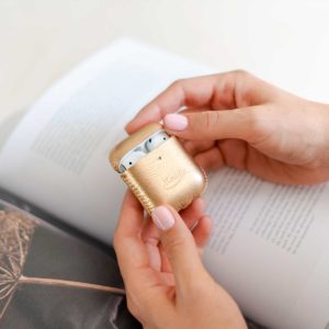 Topaz-Airpods-gold-leather-case-in-her-hands-bs