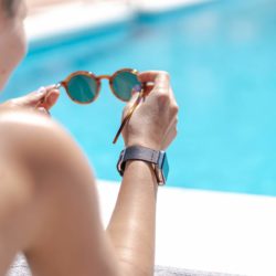 Apple-watch-black-tide-band-recycled-ocean-plastic-woman-handles-own-eyewear-close-to-a-swimming-pool