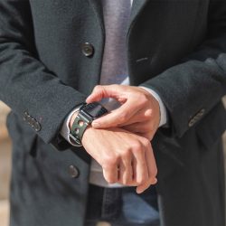 AW green full grain leather band for man wearing a coat in a sunny day